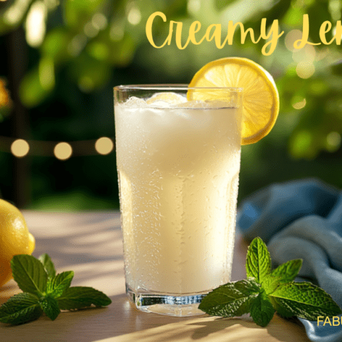 clear glass of creamy lemonade with lemon slice garnish on a wooden tabletop